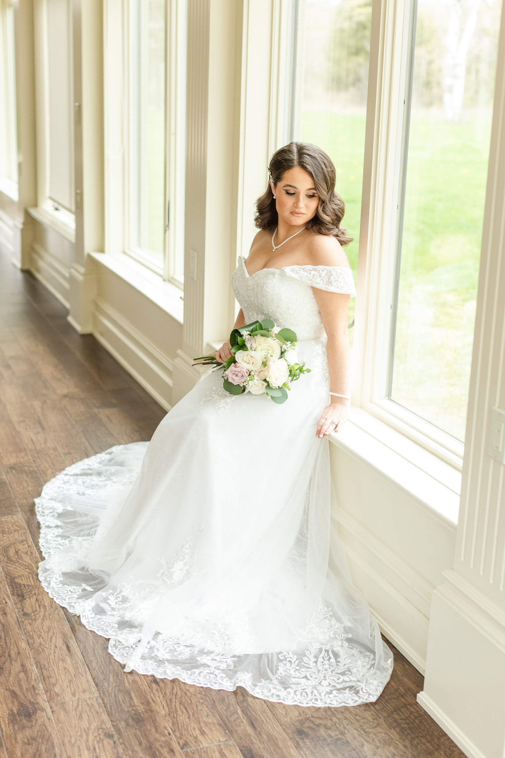 A sparkling gown named Elizabeth with an on or off-shoulder design, sweetheart neckline, and intricate sequin embellishments on the bodice. The dress features a beaded waistline, chapel length train with embroidered lace appliqués, and a corset back design.